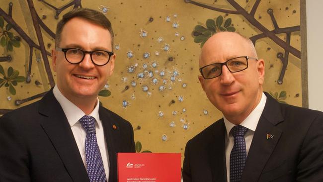 Andrew Bragg hands Coalition financial services spokesman Luke Howarth a copy of his report into ASIC. Photo: Supplied