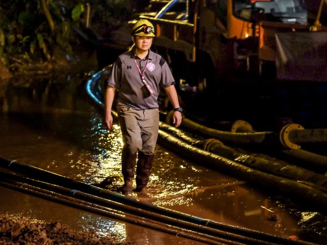 A rescuer walks between the hoses which are carrying water out of Tham Luang Nang Non cave. Picture: Linh Pham/Getty Images