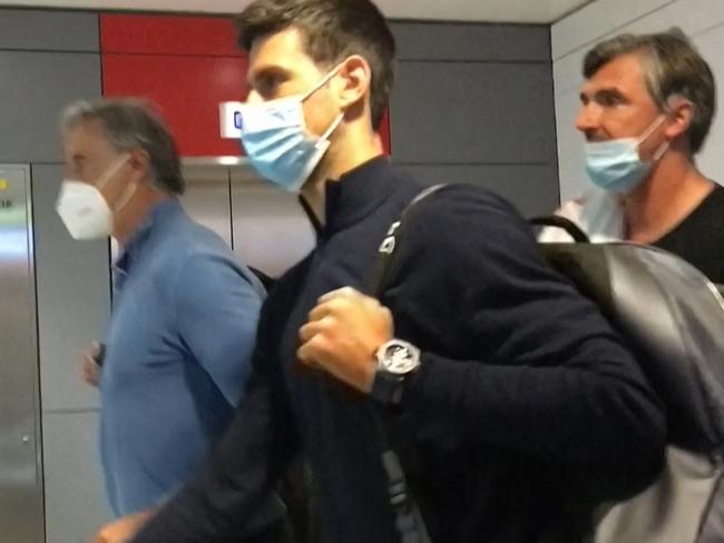 TOPSHOT - This screen grab from AFPTV shows Serbia's Novak Djokovic (C) as he disembarks from his plane at the airport in Dubai on January 17, 2022, after losing a legal battle on January 16 in Australia to stay and play in the Australian Open tennis tournament over his coronavirus vaccination status. (Photo by AFPTV / AFP)