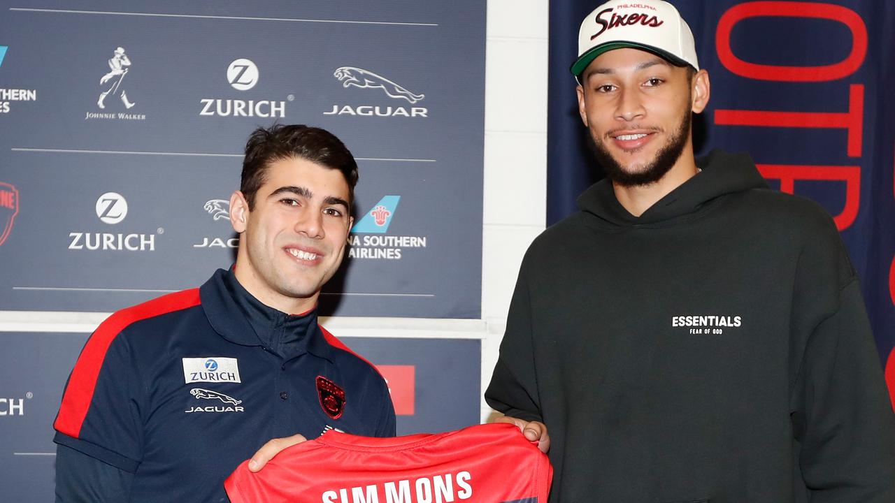 MELBOURNE, AUSTRALIA - AUGUST 10: Christian Petracca of the Demons presents Ben Simmons with a jumper before the 2019 AFL round 21 match between the Melbourne Demons and the Collingwood Magpies at the Melbourne Cricket Ground on August 10, 2019 in Melbourne, Australia. (Photo by Michael Willson/AFL Photos via Getty Images)