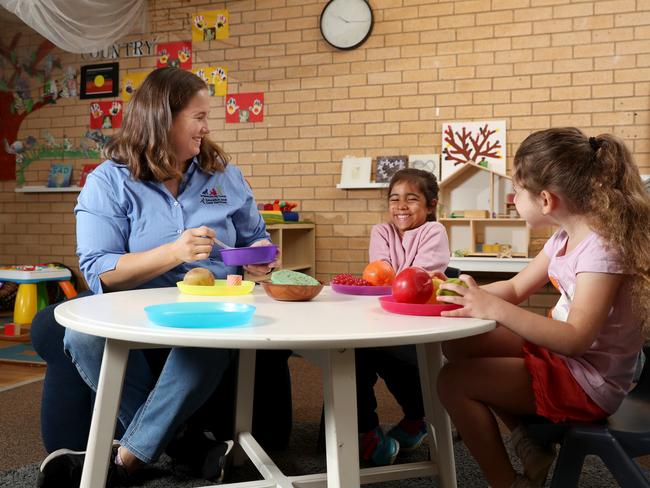 Early childhood teacher Rebecca Gibbs with children Charlotte, 4, and Sienna, 4, (right) at Amber Cottage Early Learning Centre in Ambarvale. Council childcare centres face closure because they canâ€™t get Jobkeeper, unlike private operators. Picture: Jonathan Ng