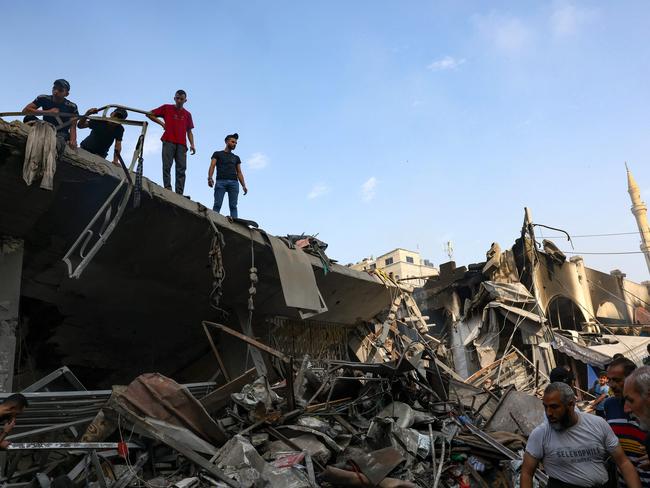 People check the destruction following Israeli strikes on Al-Shatee camp in Gaza City on October 28, 2023. (Photo by MOHAMMED ABED / AFP)