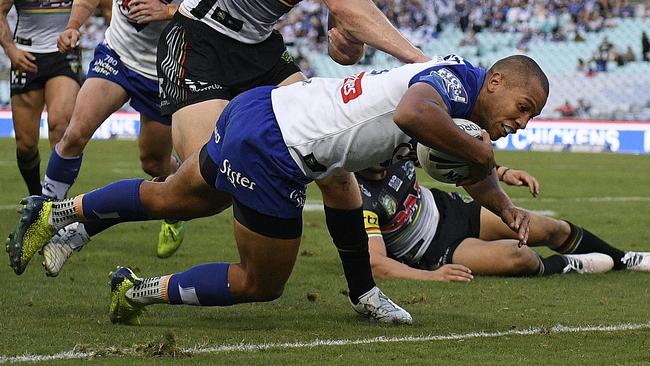 Moses Mbye of the Bulldogs gets through a tackle to score a try.