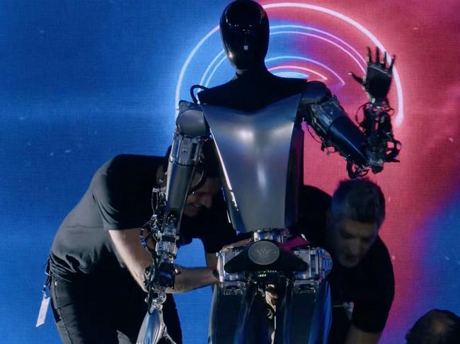 This video screen grab made from Tesla AI Day 2022 livestream shows staff bringing Optimus the humanoid robot, on stage in Palo Alto, California on September 30, 2022. (Photo by various sources / AFP) / RESTRICTED TO EDITORIAL USE - MANDATORY CREDIT "AFP PHOTO / HANDOUT / TESLA " - NO MARKETING - NO ADVERTISING CAMPAIGNS - DISTRIBUTED AS A SERVICE TO CLIENTS