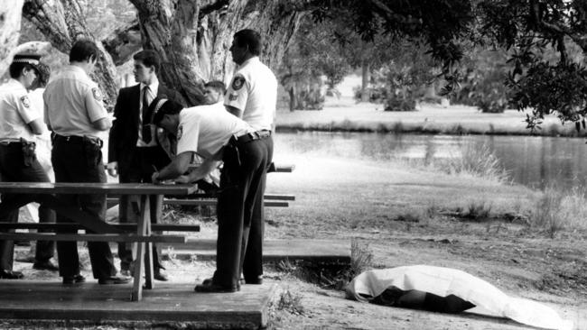 Police officers next to the covered body of murder victim Sallie-Anne Huckstepp in Centennial Park in February 1986.