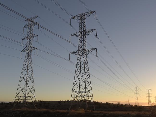 Power lines hang from transmission towers on Torrens Island, South Australia, on Monday, April 2, 2018. A plan byÃÂ Tesla Inc.ÃÂ to build the world's largest virtual power plant may be in jeopardy after the South Australian political party that championed the deal was ousted from government, setting up a potential retreat from ambitious renewableÃÂ energyÃÂ targets. Photographer: Carla Gottgens/Bloomberg via Getty Images