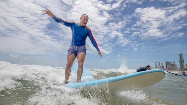 Mike Tindall, husband of the Queen’s granddaughter tried surfing on the Gold Coast. Picture Luke Marsden