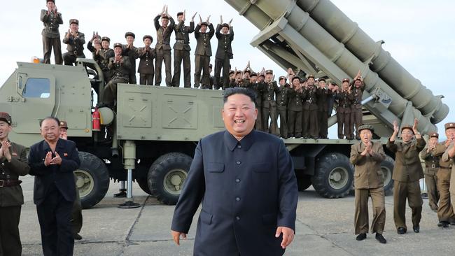 North Korean leader Kim Jong-un celebrating the test-firing of a 'newly developed super-large multiple rocket launcher' at an undisclosed location in 2019. Picture: KCNA via KNS