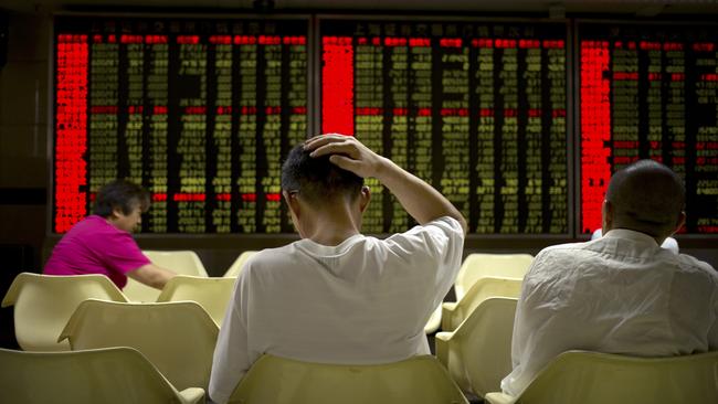 Investors monitor displays of stock information at a brokerage house in Beijing, Wednesday, July 15, 2015. Shanghai stocks lost ground on Wednesday despite China's better-than-expected economic growth in the second quarter, with investors still wary after a big slide in Chinese markets. (AP Photo/Mark Schiefelbein)