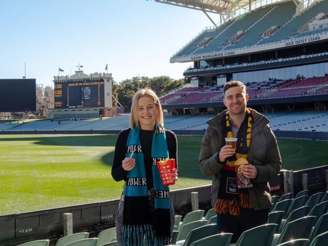 Alice McKeough and Lachlan McLeod celebrating the SMA reducing the price of popular food and beverage items at Adelaide Oval ahead of the AFL returning.