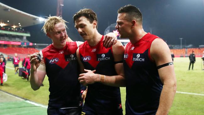 Demons Clayton Oliver, Jake Lever and Steven May embrace each other after the weekend’s gritty win over Gold Coast. Picture: Cameron Spencer/Getty Images