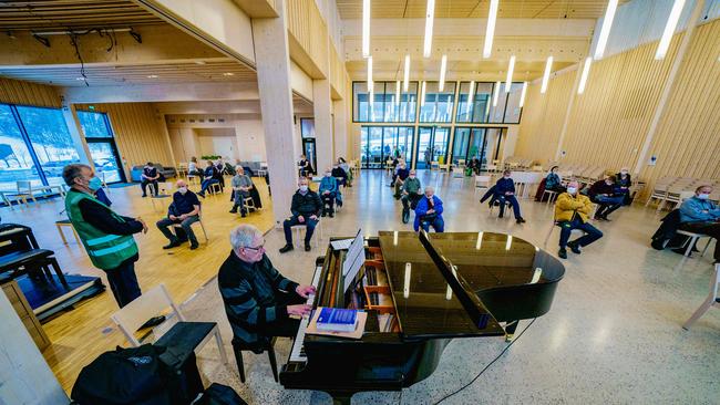 Norwegian pianist Ove Nyvik entertains elderly residents from Nittedal, some 20 kilometres outside Oslo, as they wait for their coronavirus vaccination. Picture: AFP