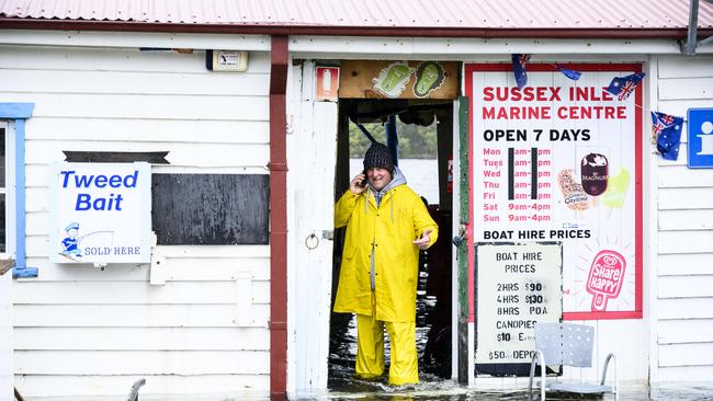 Richard Green walks through floodwaters which inundated his Sussex Inlet business. Picture: Darren Leigh Roberts