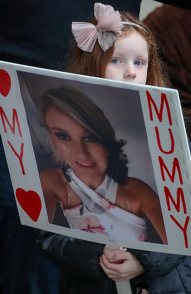 The daughter of murder victim Katie Haley holds a picture of her mother during the No More Rally into violence against women. Picture: Ian Currie