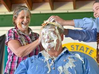 CREAMED: Mt Larcom State School principal Pauline Porch and student Shalom White have a laugh as teacher Norm Horan cops a caramel cream pie in the face. The school helped raise money for drought relief. Picture: Mike Richards GLA140918PIEF