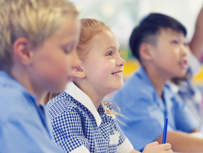 Generic photo of happy students in their classroom wearing their school uniform