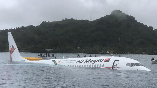 Locals approach the crashed Air Niugini aircraft on the remote Island of Weno, in Micronesia. Picture: James Benito/AFP