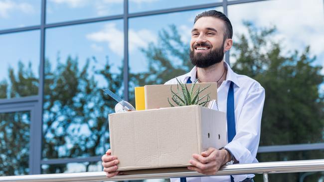 happy businessman with cardboard box with office supplies in hands standing outside office building, quitting job concept. quit job happy. ISTOCK