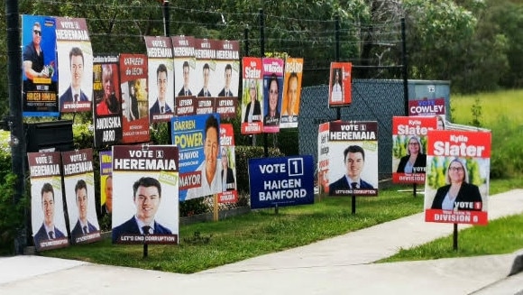 Signs outside the Browns Plains voting booth this morning where there was limited parking after candidate Jacob Heremaia parked a trailer on the side of the driveway to the polling station.