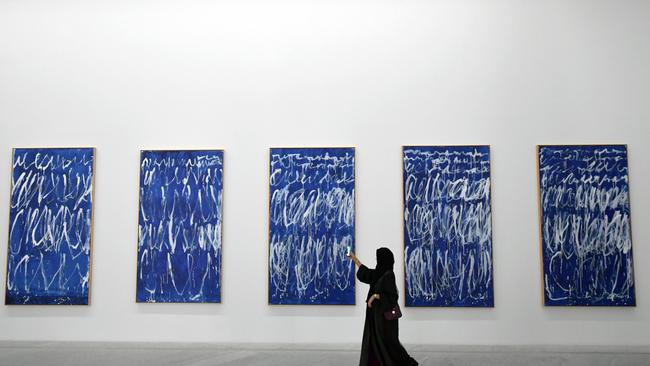 A visitor takes a photo of a piece of a series of nine panels titled "Untitled I-IX" by American artist Cy Twombly at the Louvre Abu Dhabi.