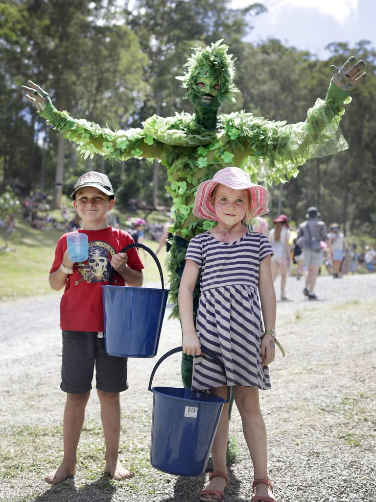 Tree man Ross Horrocks gets help watering plants on site with Cade Walker, 6, and Luka McHenry-Williams, 5, at the Woodford Folk Festival. Picture: Megan Slade/AAP