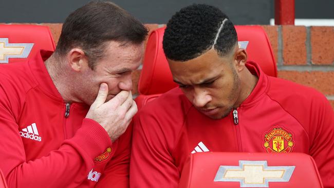 Substitute, Manchester United's English striker Wayne Rooney, talks to Manchester United's Dutch midfielder Memphis Depay (R)