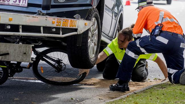 Emergency services working to remove the bike from underneath the car. Picture: Jerad Williams