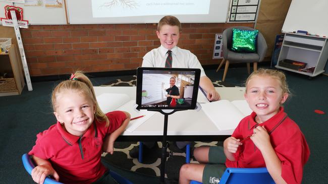 St Paul’s teacher Laura Kenny beams in via an iPad to teach the Page children Madeline, 6, Emmanuel, 9, and Anabelle, 7. Picture: Annette Dew