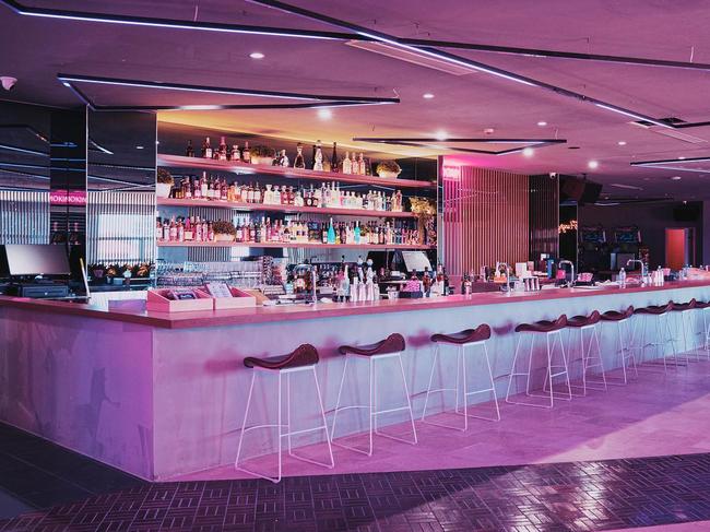 Interior of VIP Karaoke bar, empty, lit with pink neon.