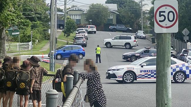 Students at Wilston State School look on as police close off the street after a stabbing. Picture: Rose Innes