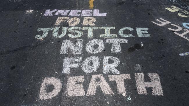 "Kneel for Justice not for Death" is written on the road outside the Cup Foods, where George Floyd was killed in police custody. Picture: Getty Images