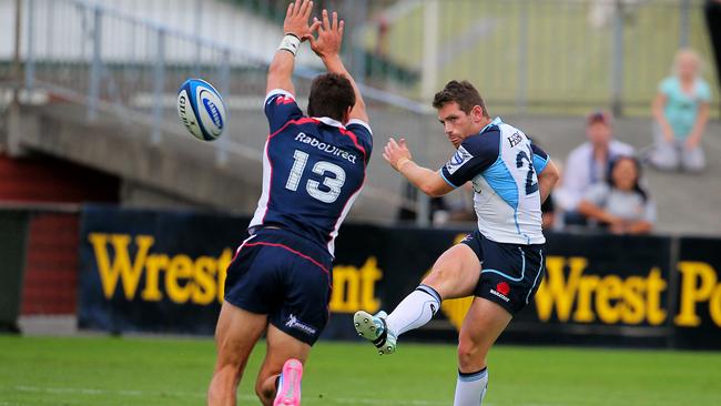 Bernard Foley clears under pressure from the Waratahs.