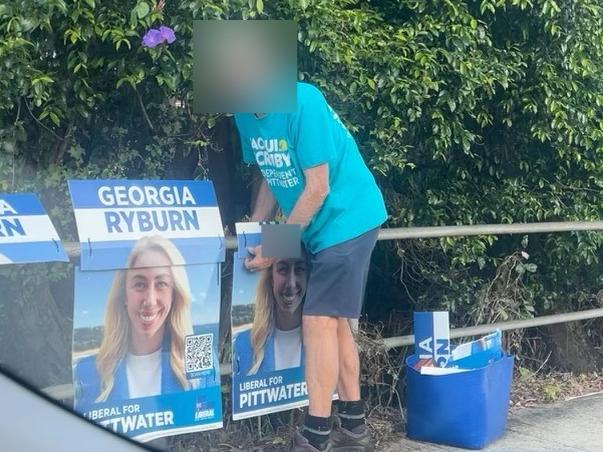 A photograph purporting to show a supporter of Jacqui Scruby, the independent candidate in this Saturday’s Pittwater state by-election, tearing down and binning campaign posters for Liberal candidate Georgia Ryburn.