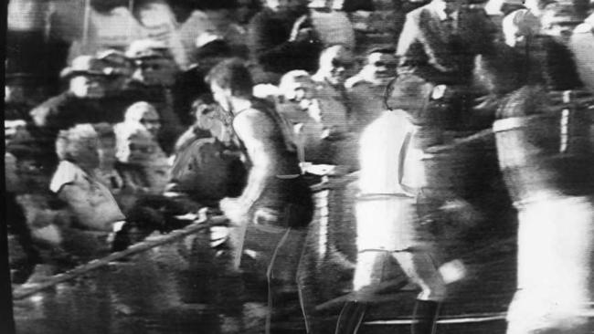 Chris McDermott approaches a Port supporter after being donked on the head from the crowd during an SANFL game between Glenelg and Port Adelaide in 1988.