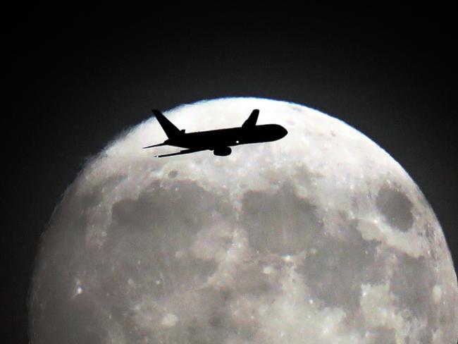 A commerical jet flies in front of the moon on its approach to Heathrow airport in west London on November 13, 2016. Tomorrow, the moon will orbit closer to the earth than at any time since 1948, named a ‘supermoon’, it is defined by a Full or New moon coinciding with the moon’s closest approach to the Earth. Picture: AFP PHOTO / Adrian DENNIS