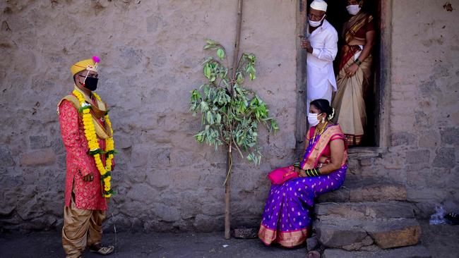 Groom Vitthal Koditkar. left, of Hirpodi village speaks with his bride, Vrushali Renuse, of Pabe village and family members after their wedding during lockdown in the Pune district of India. Picture: AFP