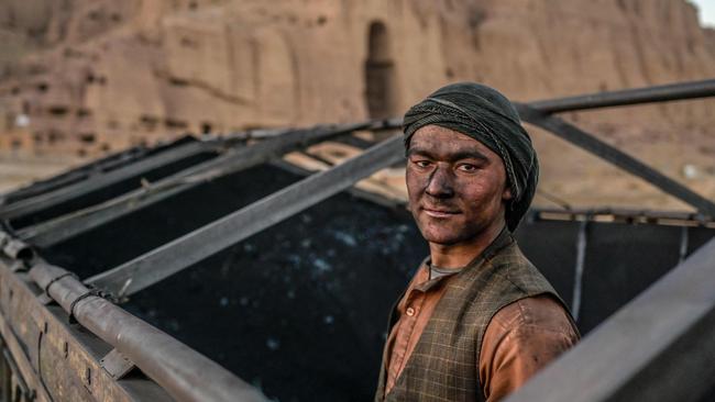 A Hazara worker loads coal onto a truck near the site where the Salsal Buddha statue once stood before being destroyed by the Taliban in Bamiyan province, Afghanistan. Picture: AFP