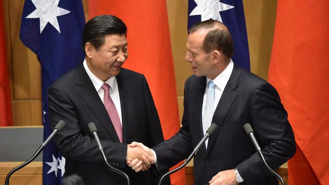 China's President Xi Jinping shakes hands with then-prime minister Tony Abbott following the signing of a free trade agreement at Parliament House in Canberra on November 17, 2014.