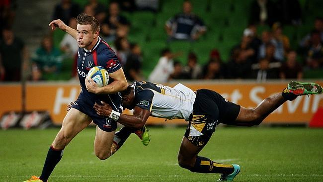 Rebels fullback Jason Woodward tries to beat the tackle of Brumbies centre Tevita Kuridrani.