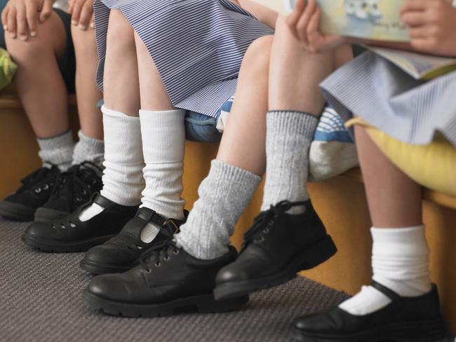 Low section of elementary students sitting in row in classroom