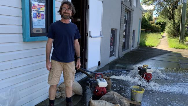 Mark Conaghan, the Committee President of the Penguin Playhouse Theatre Company, surveys water flooding the community theatre on Through Street, South Grafton.