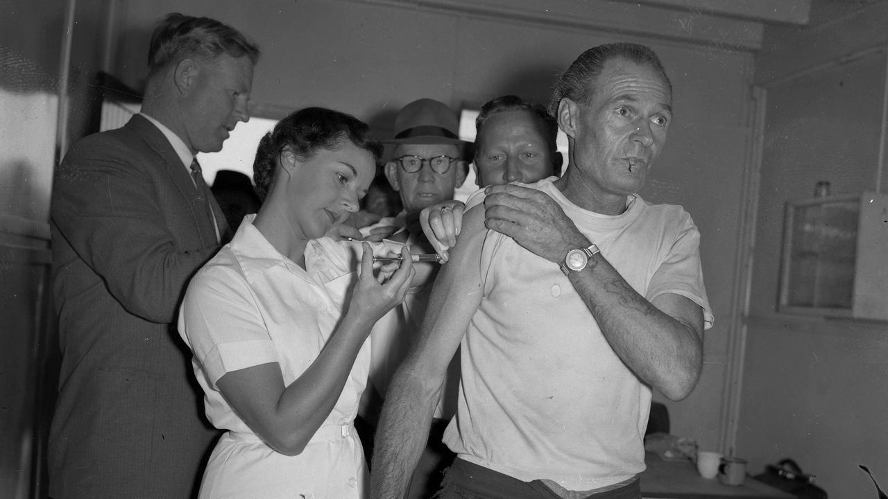 A nurse administers anti-flu vaccinations to workers in 1958. Picture: Ray Saunders