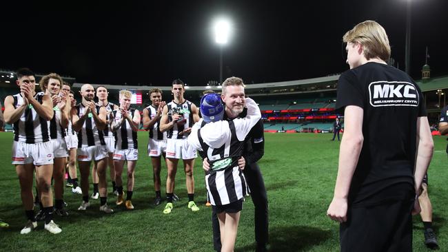 Magpies head coach Nathan Buckley celebrates victory with sons Ayce (L) and Jett (R) after coaching his final game.