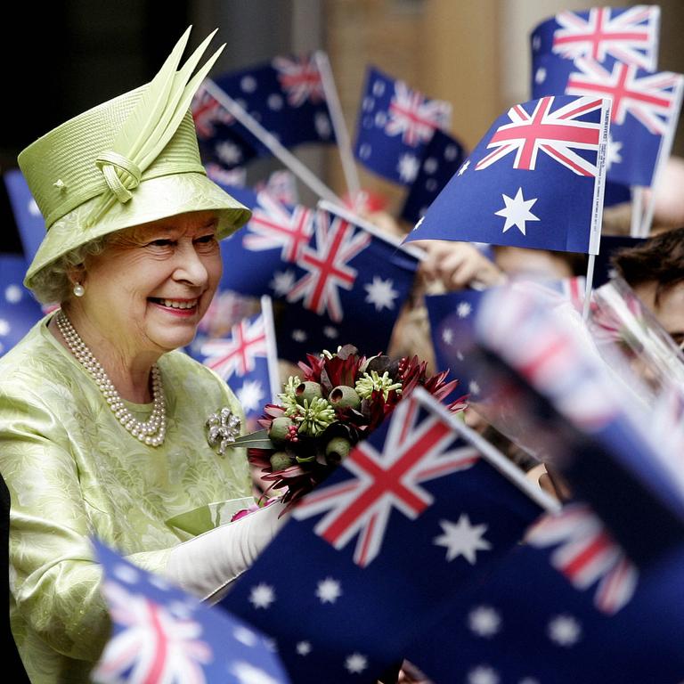 Queen Elizabeth II receives flowers from waiting school children waving national flags after the Commonwealth Day Service in Sydney in 2006 (Photo by ROB GRIFFITH / POOL / AFP)