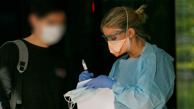 Patient wearing mask with face blurred is seen by triage nurse at Northern Beaches Hospital's new COVID-19 clinic. Picture: Tim Pascoe