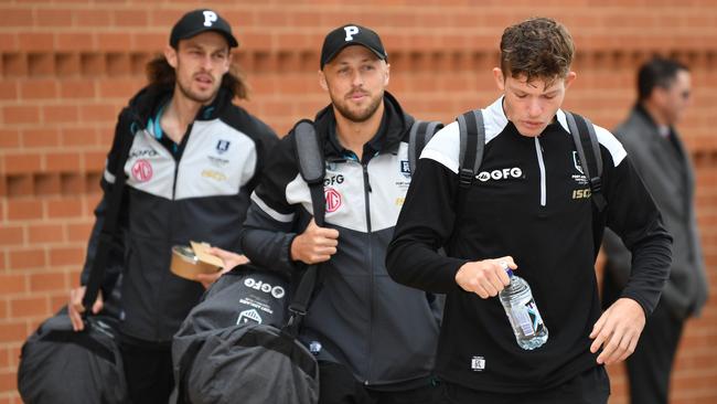 Port Adelaide players, from left, Jarrod Lienert, Cam Sutcliffe and Mitchell Georgiades at Alberton Oval on Friday, where the team departed for the Gold Coast AFL hub. Picture: AAP