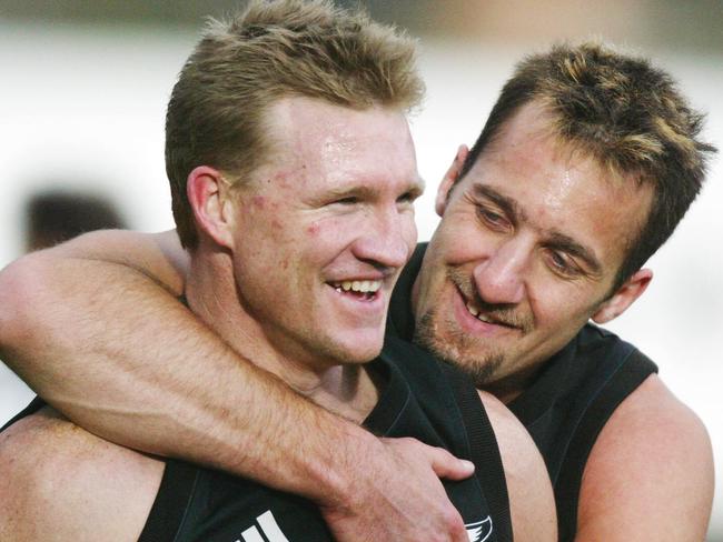 25/09/2003:  Anthony Rocca gives Nathan Buckley a kiss and a hug at Collingwood football training. DIGITAL IMAGE.