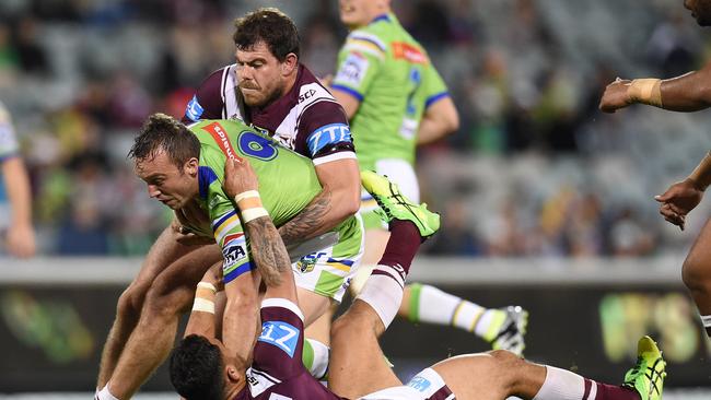 Josh Hodgson of the Raiders is tackled by Manly’s Dylan Walker and Josh Starling.