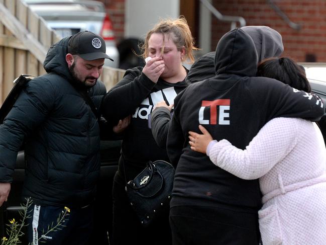 Relatives and friends of the deceased outside a house on Tuesday. Picture: Andrew Henshaw