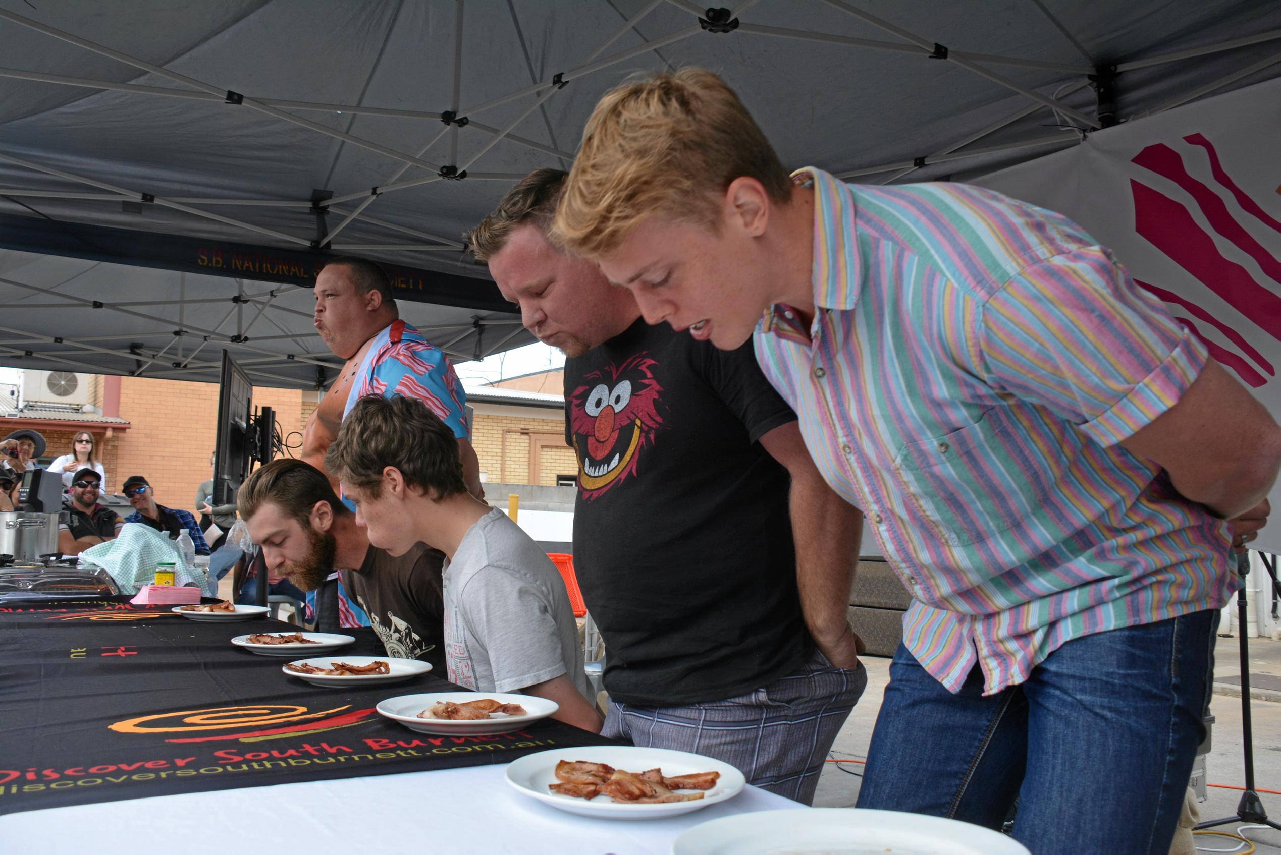 Competitors fight for the top spot at the bacon eating competition during Kingaroy's BaconFest on Saturday August 25. Picture: Jessica McGrath